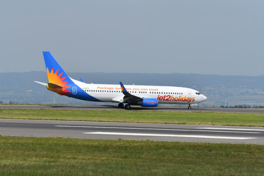 Jet2holidays airplane on the runway ready for takeoff at a scenic airport.